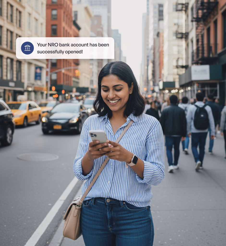 A woman standing in a busy street, lookng at her phone and smiling at the notification "Your NRO bank account has been successfully opened!"