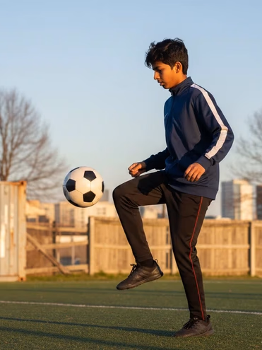 Young boy playing football in an open field
