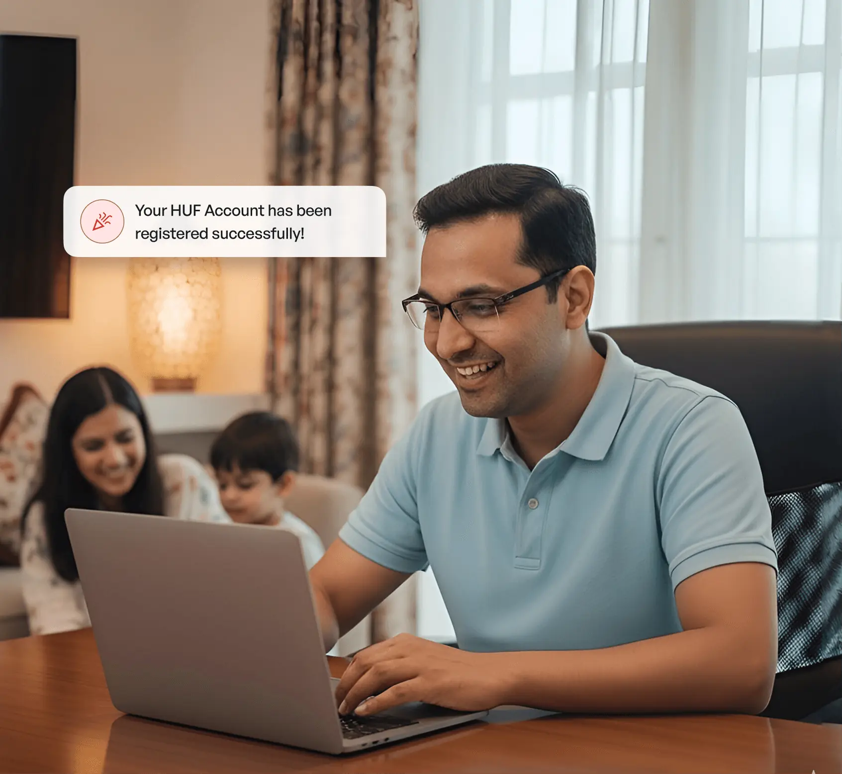 Man smiling while using a laptop at home, with family in the background and a notification confirming HUF account registration.